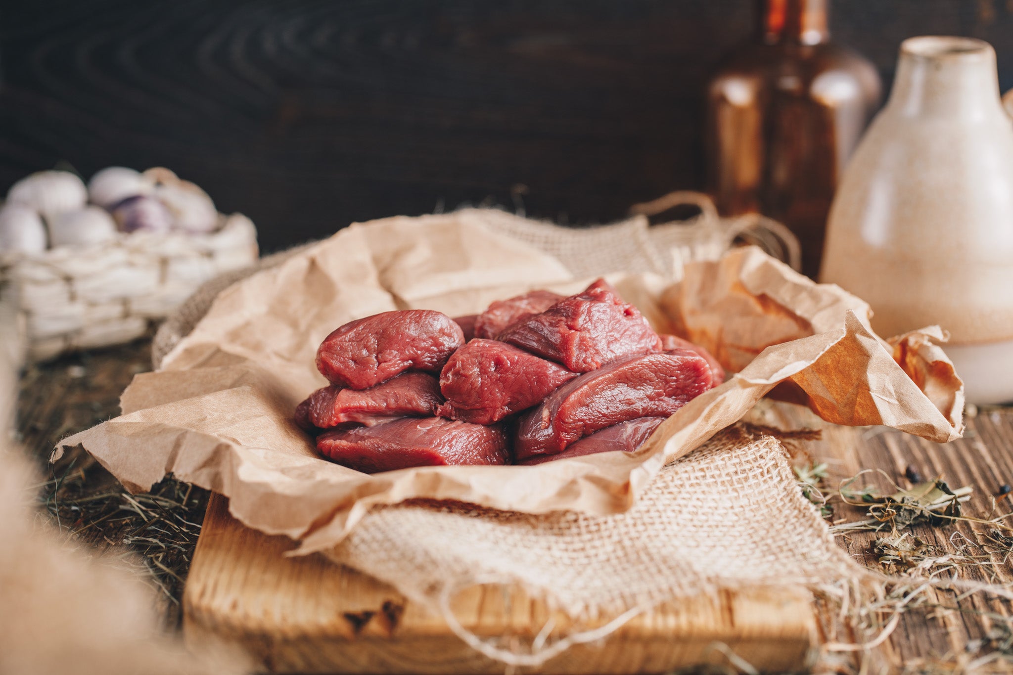 Ager Tirol Hirschfleisch Hirschgulaschfleisch roh auf Holzbrett und Heu 500g