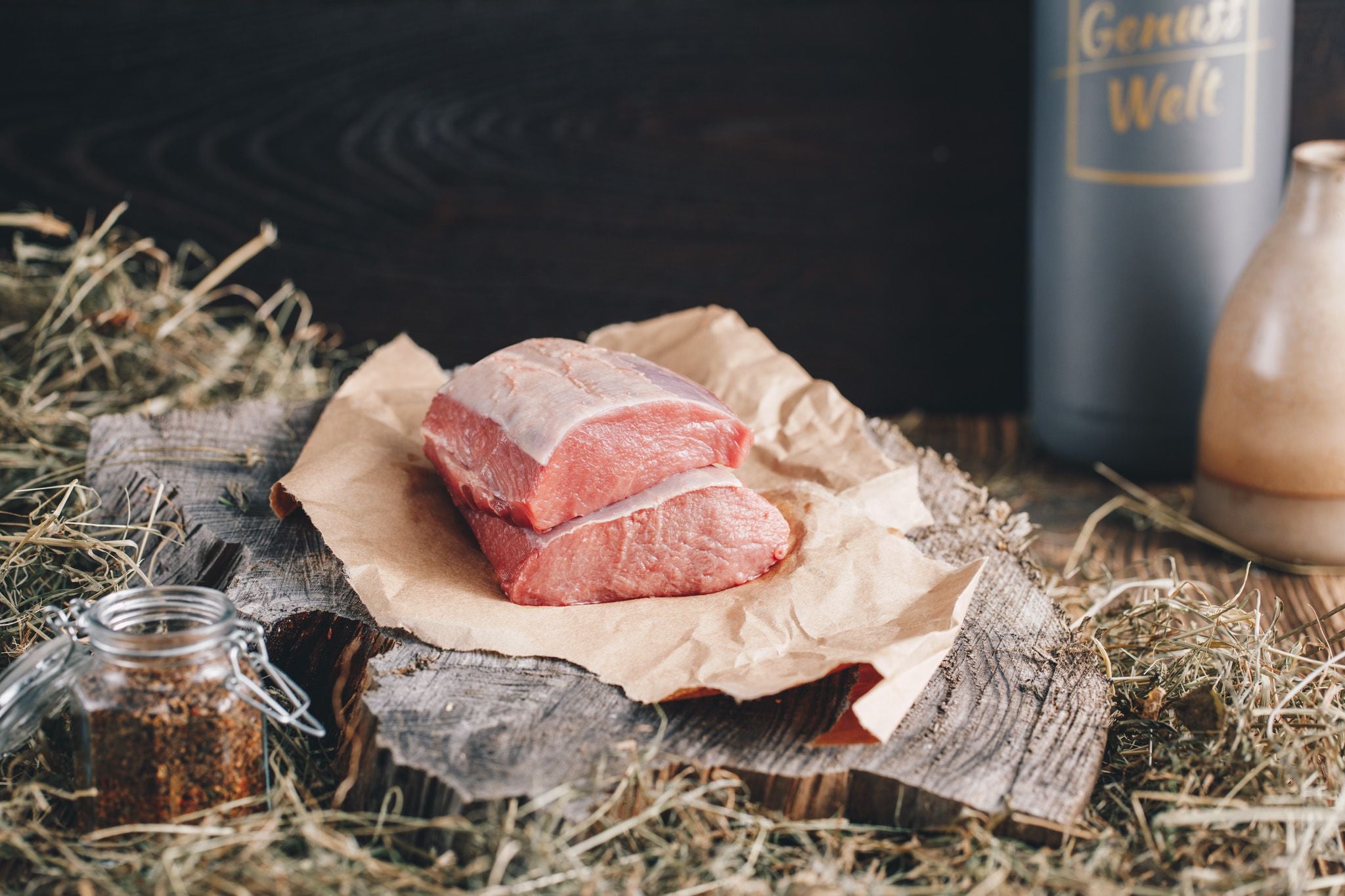Ager Tirol Wildschweinfleisch zwei Wildschweinrückensteaks roh auf Holzbrett und Heu mit 360g