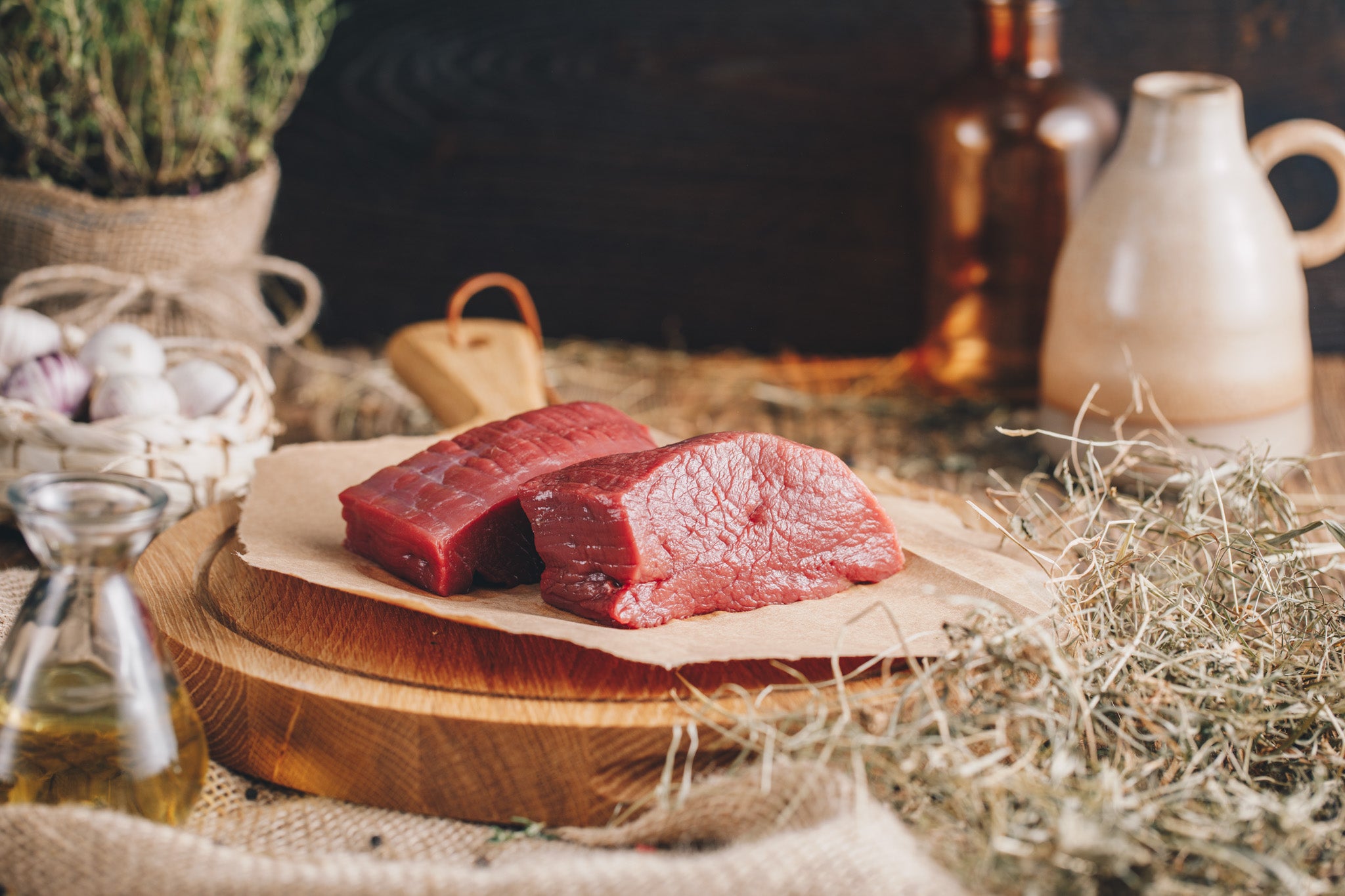 Hirschsteaks aus der Keule von Ager auf rustikalem Holzbrett
