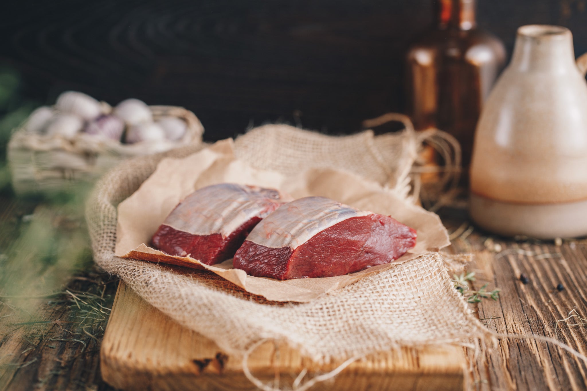 Ager Tirol Hirschfleisch zwei Hirschrückensteaks roh auf Holzbrett und Heu mit 360g